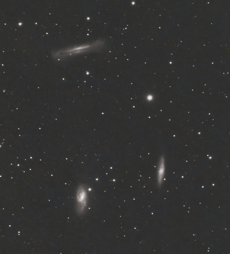 Astrophotography image of the Leo Triplet galaxy group centered on Messier 65 against a dark star field.